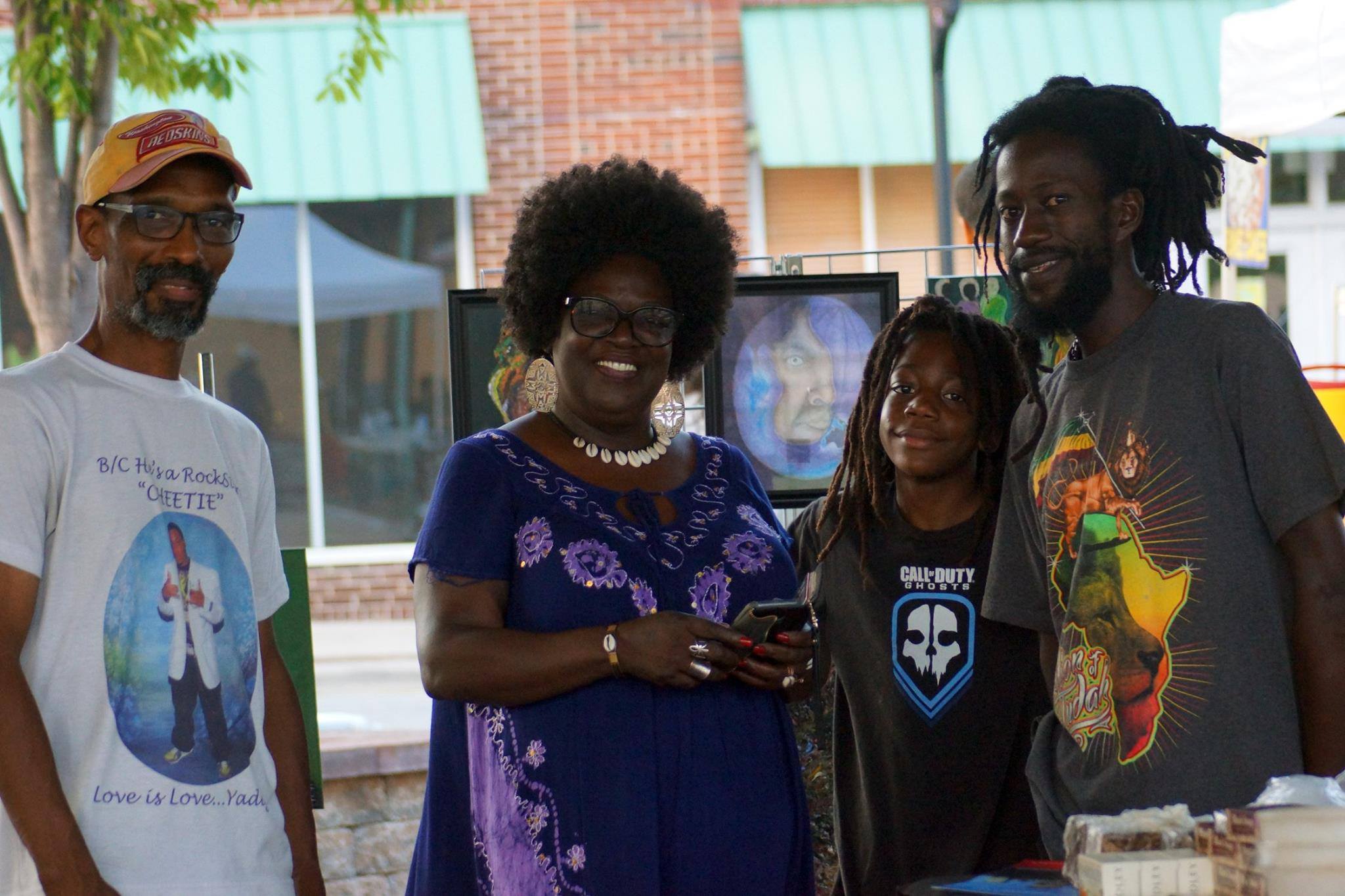 A family standing together at a community vendor booth